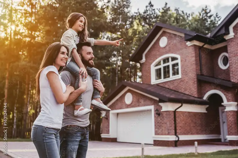 A family outside their home after a Cardinal Premier Roofing roof replacement